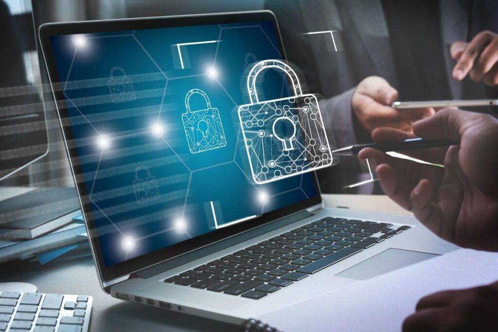 Laptop screen displays glowing padlock icons and a security network theme, illustrating cybersecurity.