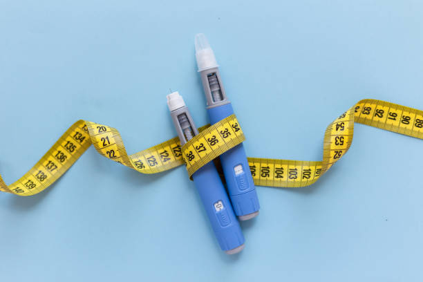 image - Lead Grow Develop - Business, Technology, Personal Development Two blue insulin pens with a yellow measuring tape wrapped around them on a light blue background, illustrating diabetes management tools.