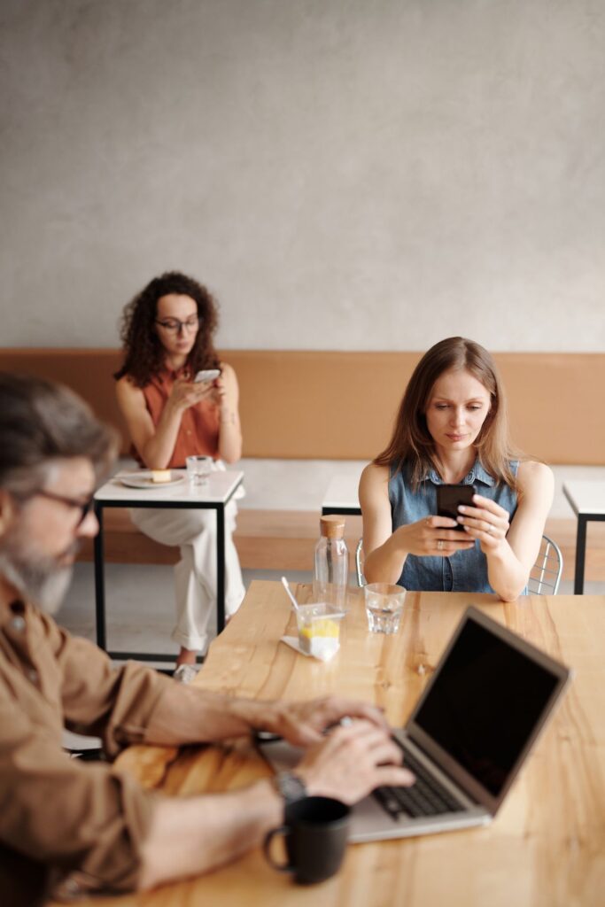 pexels-edmond-dantes-4345357 - Lead Grow Develop - Business, Technology, Personal Development Adults engaging with phones and laptop in a modern coffee shop setting