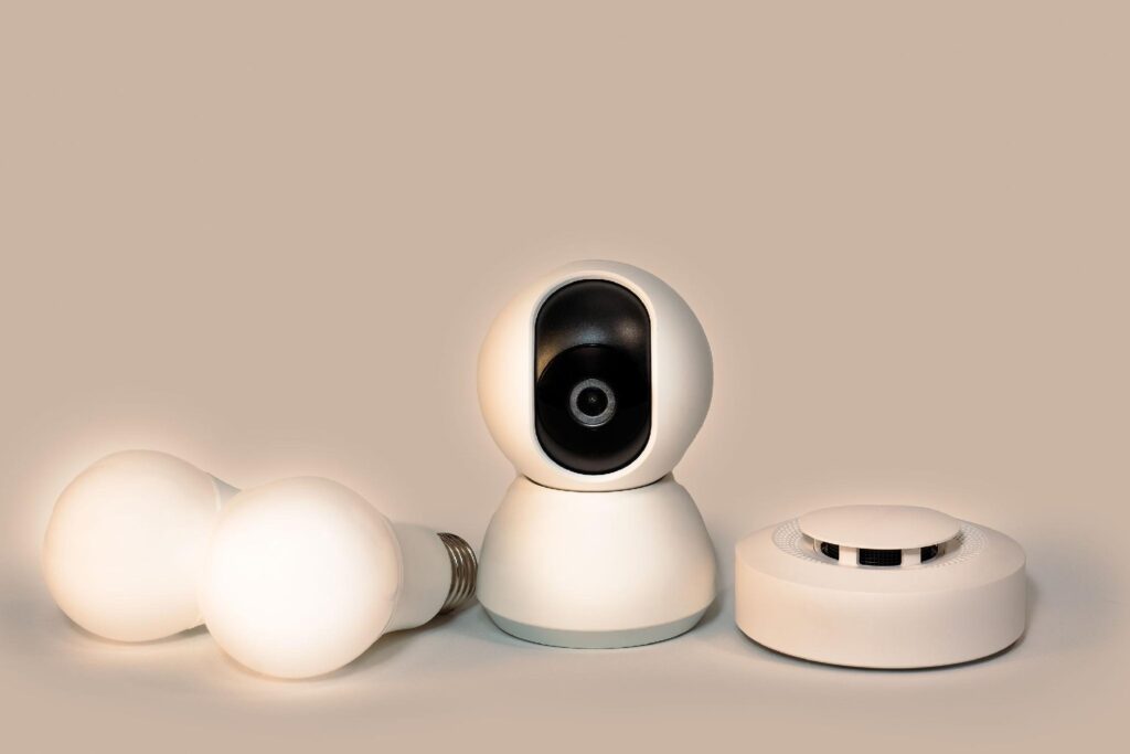 White spherical robots with black camera-like faces clustered together on a surface; warm studio lighting in the background.