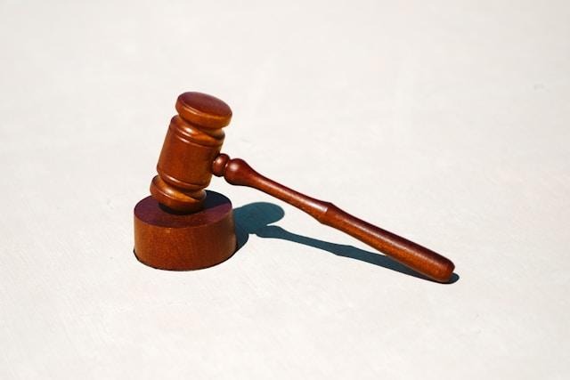 image - Lead Grow Develop - Business, Technology, Personal Development Wooden judge's gavel resting on a light surface with a shadow nearby, symbolizing a legal decision.