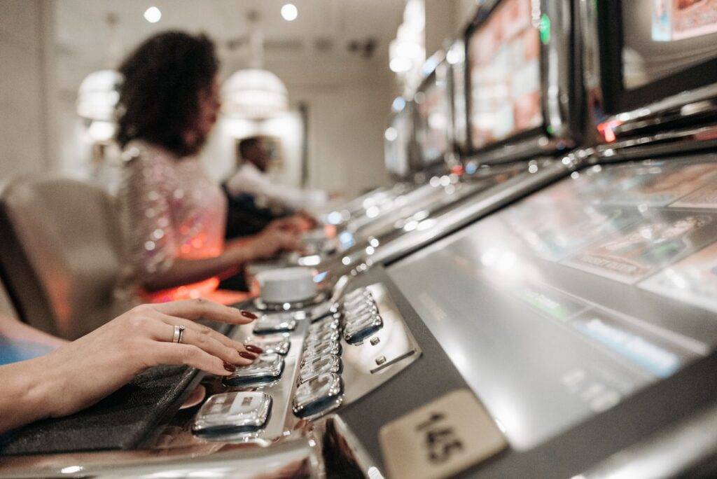 pexels-pavel-danilyuk-7594259 - Lead Grow Develop - Business, Technology, Personal Development Close-up view of hands playing slot machines in a casino setting