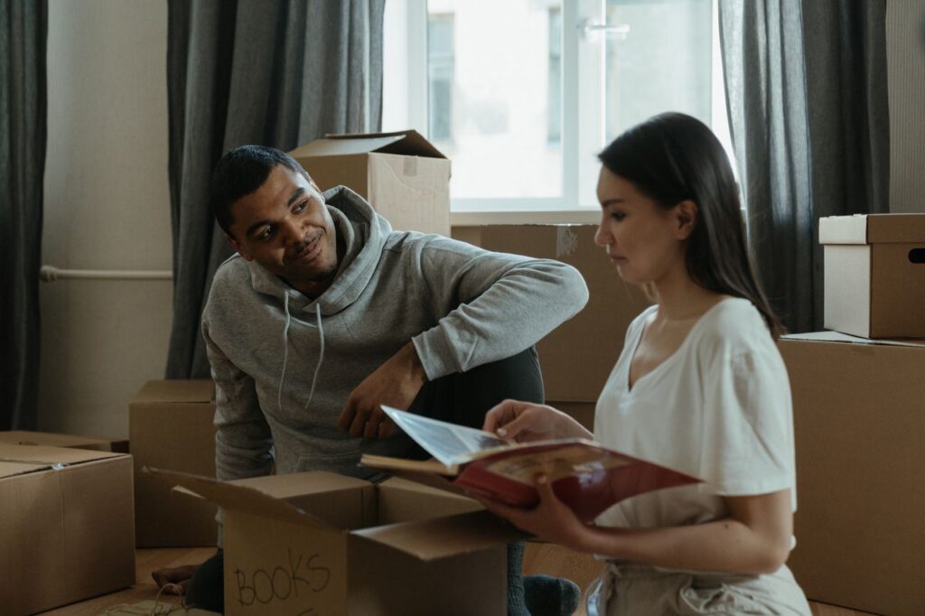 6 Essential Resources for a Smooth Apartment Move-In in Nacogdoches, TX 2 A couple exploring their new home while unpacking boxes and looking at a photo album.