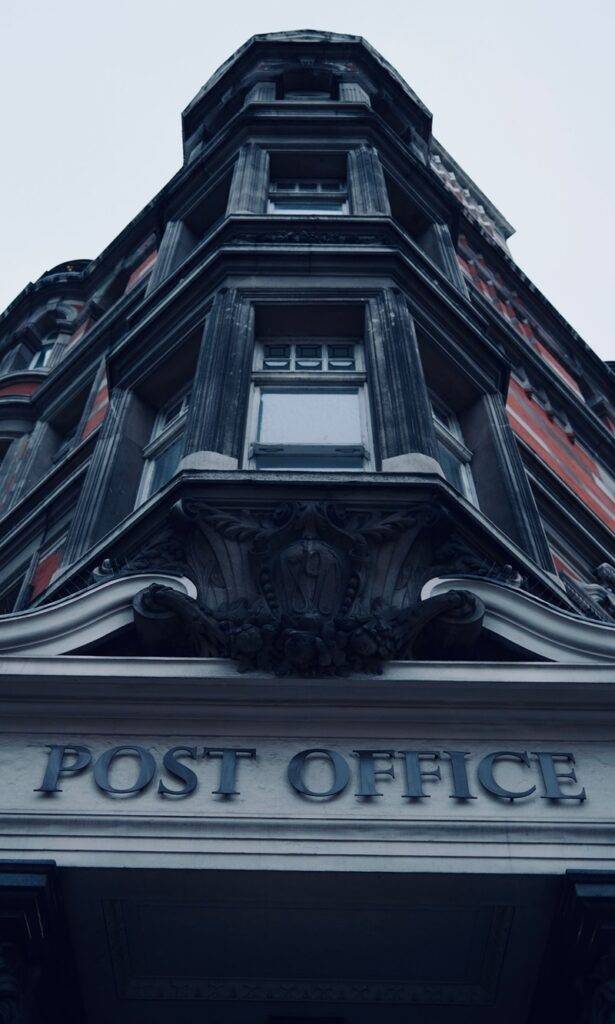 A low angle shot of a classic post office facade with intricate architectural details.
