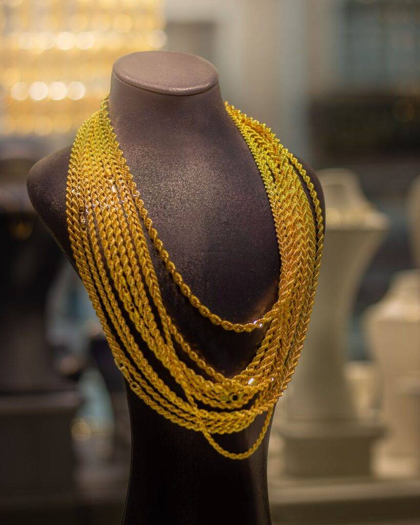 Luxurious gold necklace showcased on a mannequin in a jewelry store, highlighting elegance and style.